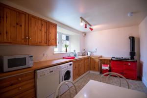 a kitchen with a washing machine and a microwave at Traditional Homely 2BD Cottage in Kemnay in Kemnay