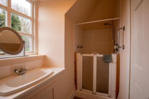 a bathroom with a sink and a shower with a mirror at Traditional Homely 2BD Cottage in Kemnay in Kemnay