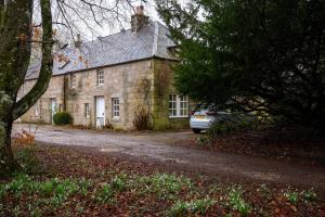 a stone house with a car parked in front of it at Traditional Homely 2BD Cottage in Kemnay in Kemnay