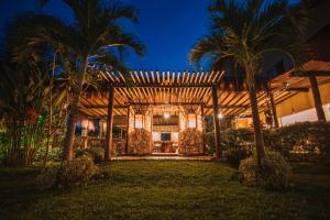 a house with palm trees in the night at Ocacocar - Milagres in São Miguel dos Milagres