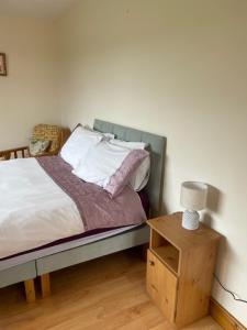 a bedroom with a bed and a table with a lamp at Hillside House - Rose Cottage in Ballinamuck