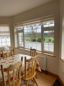 a dining room with a table and chairs and a window at Hillside House - Rose Cottage in Ballinamuck