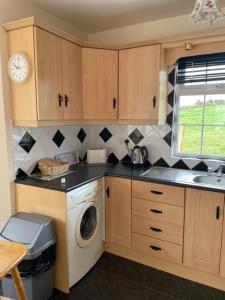 a kitchen with a washing machine and a sink at Hillside House - Rose Cottage in Ballinamuck