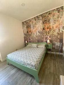 a bedroom with a green bed and a wall at Col di Lana in Cagliari