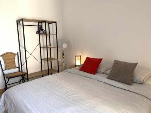 sypialnia z łóżkiem z czerwoną poduszką w obiekcie Appartement climatisé entre plage et port de Saint Mandrier w mieście Saint-Mandrier-sur-Mer