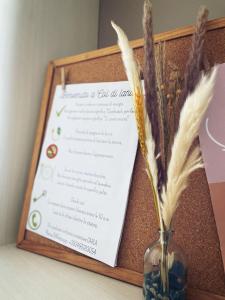 a menu in a wooden frame with a vase with flowers at Col di Lana in Cagliari