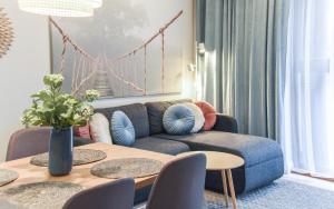 salon z kanapą i stołem w obiekcie Apartamenty Na Wyspie - Baltic Park - Apartamenty z sypialnią i parkingiem - ul Uzdrowiskowa 24-34 w Świnoujściu +37 zdjęć