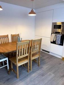 a kitchen with a wooden table with chairs and an oven at 3 bedroom terrace holiday home in Great Torrington