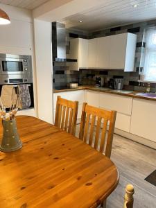 a kitchen with a wooden table and two chairs at 3 bedroom terrace holiday home in Great Torrington