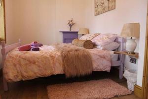 a bedroom with a bed with a comforter on it at 3 bedroom terrace holiday home in Great Torrington