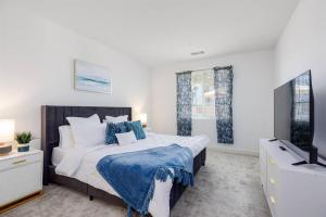 a bedroom with a large bed and a flat screen tv at Near Coachella and Stagecoach Palm Springs , PGA resort Villa ,Golf, community pool, gym in La Quinta