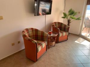Zimmer mit 2 Stühlen, einem Tisch und einem TV in der Unterkunft Daniel in Igalo