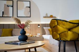 ein Wohnzimmer mit einer Vase auf einem Tisch und einem gelben Stuhl in der Unterkunft Tolevski Apartments, Bitola in Bitola
