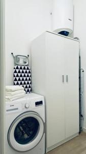 a white washing machine in a room with a refrigerator at Sun Street Apartment in Verona