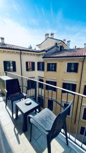 a balcony with two chairs and a table and a building at Sun Street Apartment in Verona