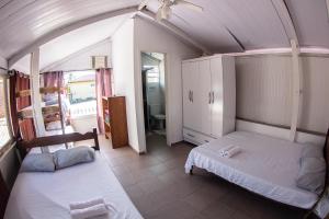 a bedroom with two beds in a room at Pousada Pérola do Guarujá Ltda- Me in Guarujá