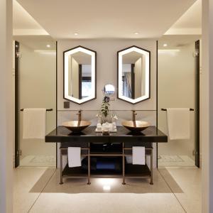 a bathroom with two sinks and two mirrors at Aleenta Retreat Chiang Mai in Chiang Mai
