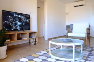 a living room with a table and a tv at Appartement climatisé entre plage et port de Saint Mandrier in Saint-Mandrier-sur-Mer