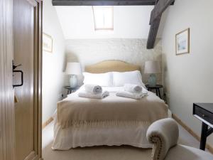 a bedroom with a bed with towels on it at The Long Barn in Ampney Crucis