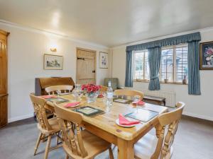 a dining room with a wooden table and chairs at Walnut Tree Cottage in Bucknell