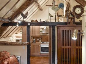 a kitchen with a clock and chickens on the ceiling at The Hayloft - Igp in Glaisdale