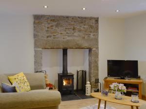 a living room with a fireplace and a couch at River Cottage in Bladnoch