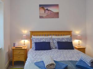 a bedroom with a bed with blue pillows at River Cottage in Bladnoch