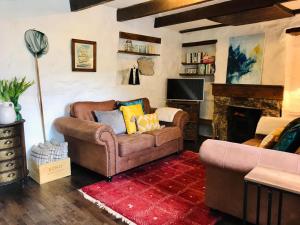 a living room with a couch and a fireplace at Market House, Mousehole in Mousehole