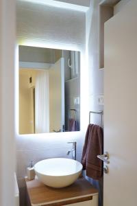 ein Badezimmer mit einem weißen Waschbecken und einem Spiegel in der Unterkunft Tolevski Apartments, Bitola in Bitola