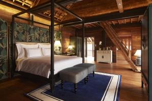 Aleenta Retreat Chiang Mai في شيانغ ماي: غرفة نوم مع سرير مظلة مع سجادة زرقاء