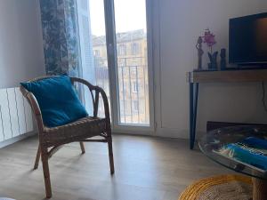 krzesło z niebieską poduszką w pokoju z oknem w obiekcie Appartement Centre-Ville w Bastii