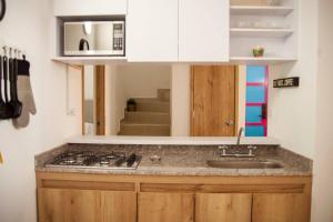 a kitchen with a sink and a stove at Apartamento amplio cerca al parque Guatape - Pajaros in Guatapé