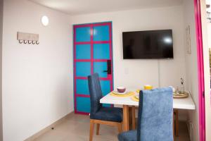 a dining room with a table and a colorful door at Apartamento amplio cerca al parque Guatape - Pajaros in Guatapé
