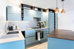 ロンドンにあるDuplex Two-Bed Apartment Near Tower Bridgeのキッチン(青いキャビネット、カウンタートップ付)