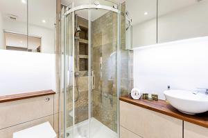 a bathroom with a glass shower and a sink at Duplex Two-Bed Apartment Near Tower Bridge in London