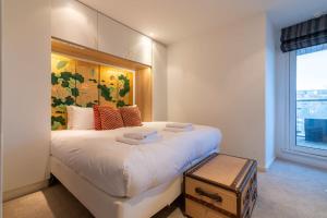 Un dormitorio con una gran cama blanca y una ventana en Regent's Canal View Apartment, en Londres