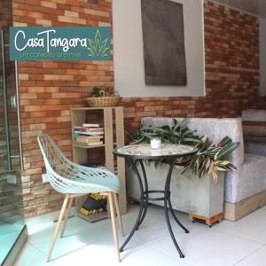 メデジンにあるCasa Tangara Café y Hospedajeのソファの横にテーブルと椅子2脚