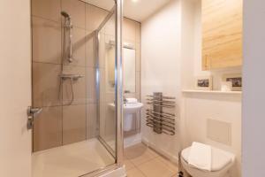 a bathroom with a shower with a toilet and a sink at Regent's Canal View Apartment in London