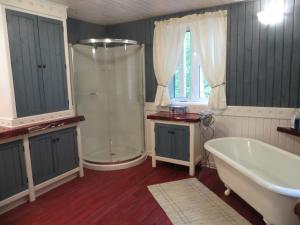 un baño con ducha y bañera en La maison sous les arbres, en Saint Roch de Mekinac 112 fotos más