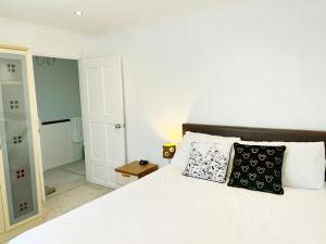 a bedroom with a white bed with two pillows on it at Khan's Living Lakeside Drive Cyncoed Cardiff in Cardiff