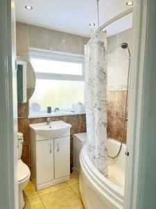 a bathroom with a toilet and a sink and a shower at Khan's Living Lakeside Drive Cyncoed Cardiff in Cardiff