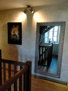 un espejo colgado en una pared junto a una escalera en La cour des Ursulines en Josselin