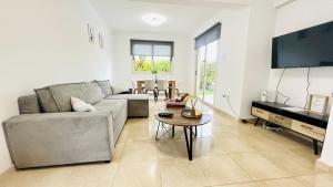 ein Wohnzimmer mit Sofa und Tisch in der Unterkunft Villa Georgina & Villa Marianda Coral Bay in Coral Bay