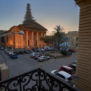 un parcheggio con auto parcheggiate di fronte a un edificio di House of Character in Valletta a La Valletta