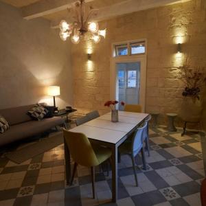 sala de estar con mesa, sillas y sofá en House of Character in Valletta, en La Valeta