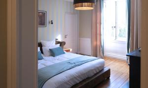 a bedroom with a bed and a large window at Château de Crespy & Suites 
