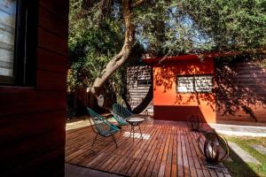 two chairs and a table on a deck with a tree at ESPACIO RAKU in Ciudad Lujan de Cuyo