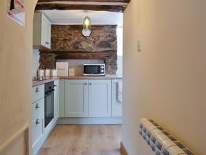 a kitchen with white cabinets and a microwave at Minallt in Nefyn