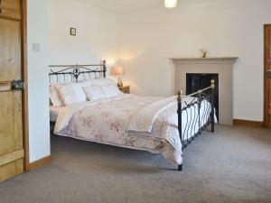 a bedroom with a bed and a fireplace at Minallt in Nefyn