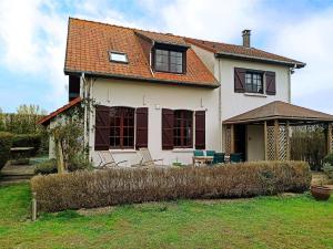 Casa blanca con ventanas marrones y patio en Les Sableaux, les portes du Marquenterre en Saint-Quentin-en-Tourmont